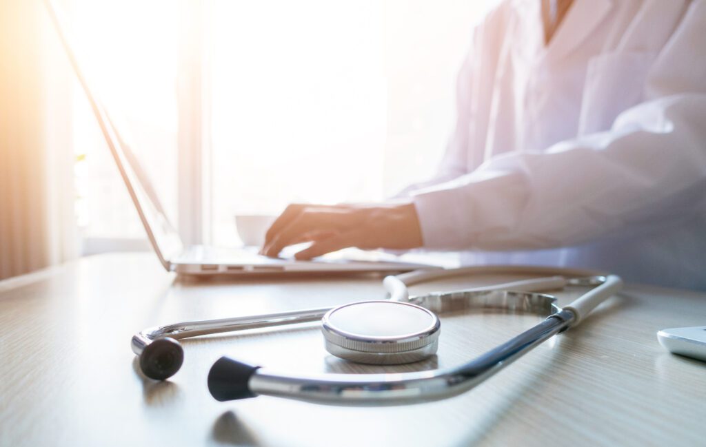 Doctor typing information on the computer in office