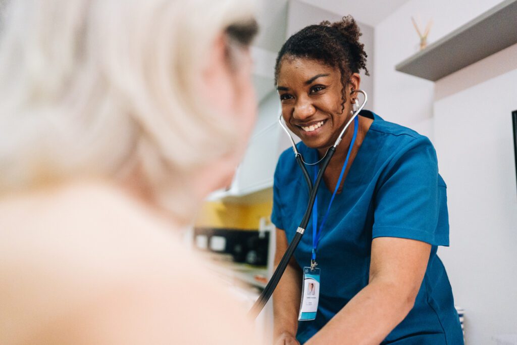Nurse taking blood pressure of a senior woman patient at home